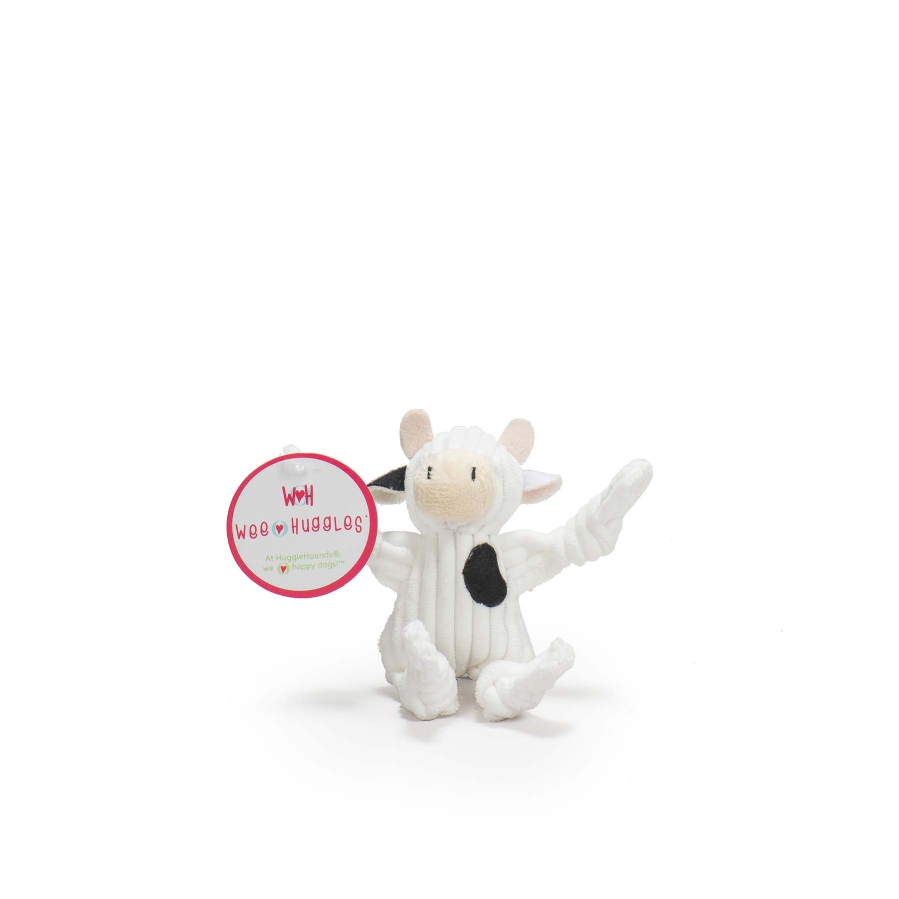 Image of the white furred cow with black spots. The cow has a black spot on it's chest, and the right ear is black as well.