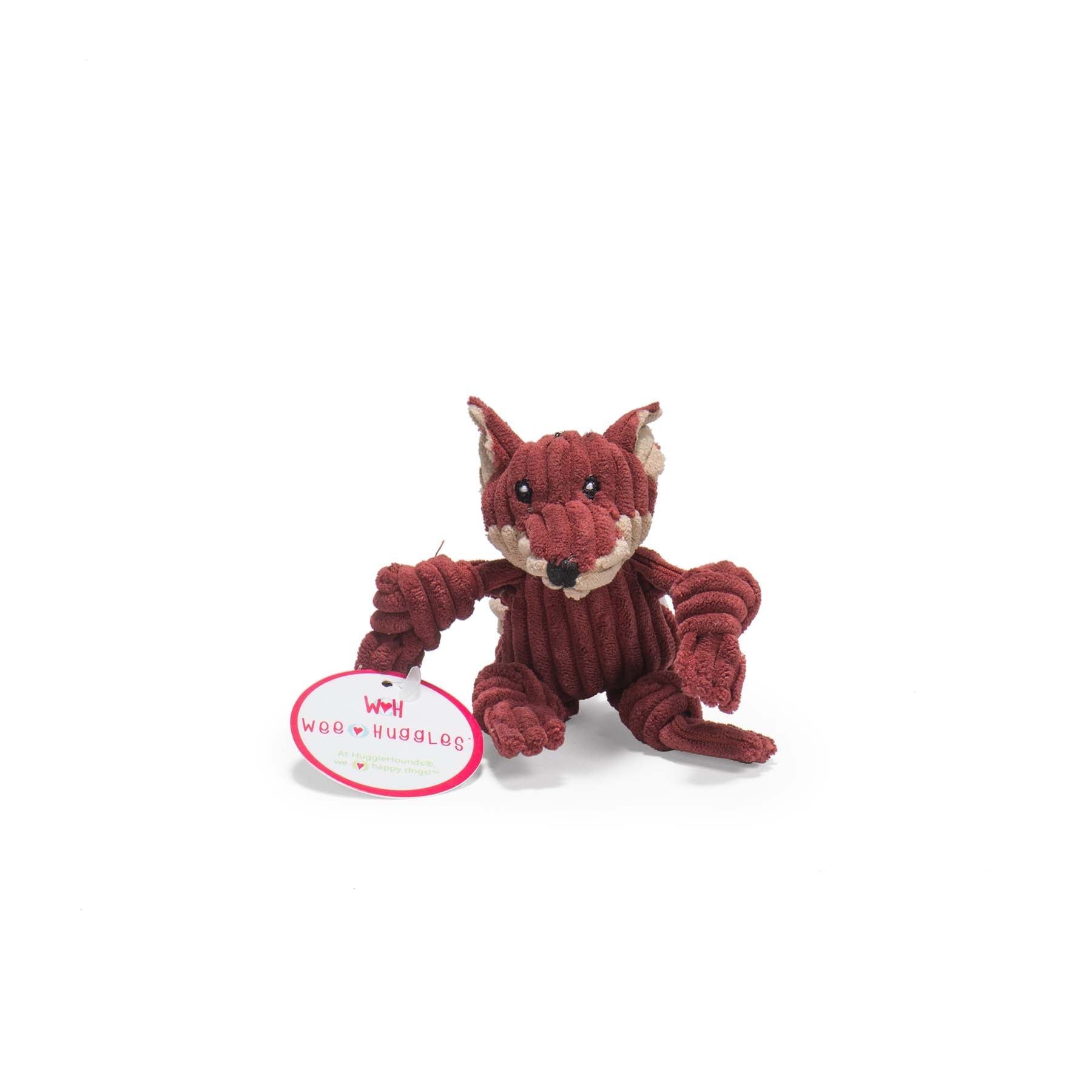 Image of the burgandy furred fox looking at the camera. The Fox has beige inner ear, with black eyes, white pupils, a black nose, and a light beige mouth.