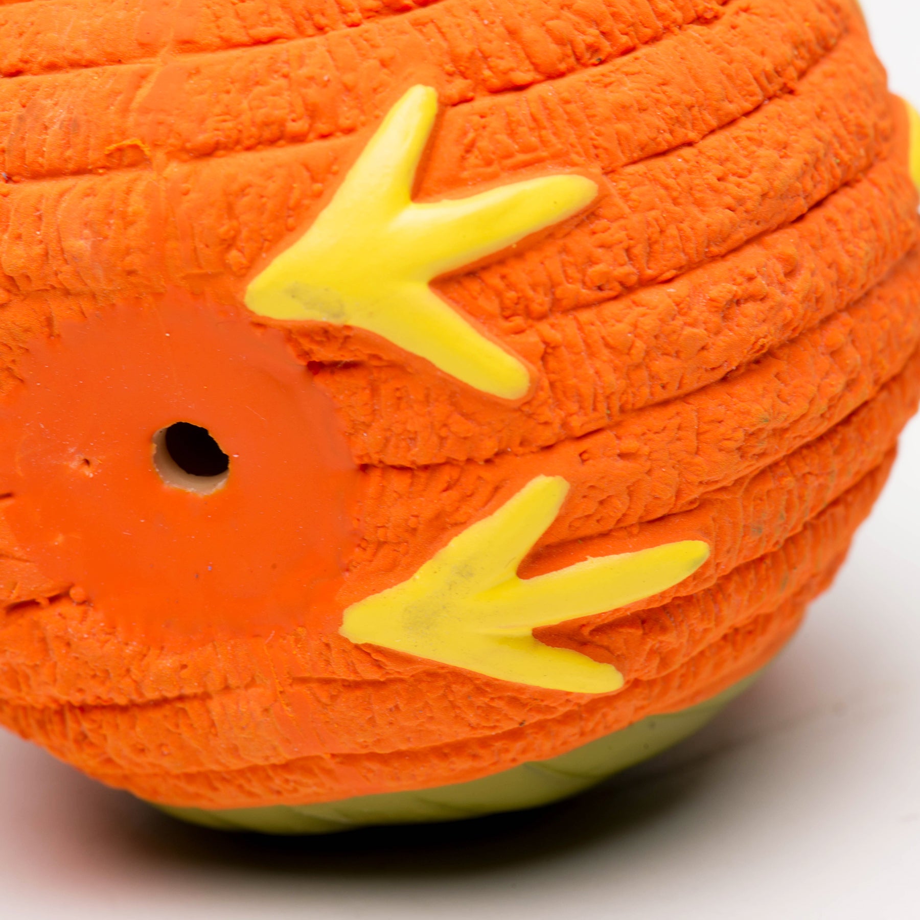 Close image of the bottom of Poppy the Owl. The bottom shows the yellow feet, orange fur, and a little hole for air.