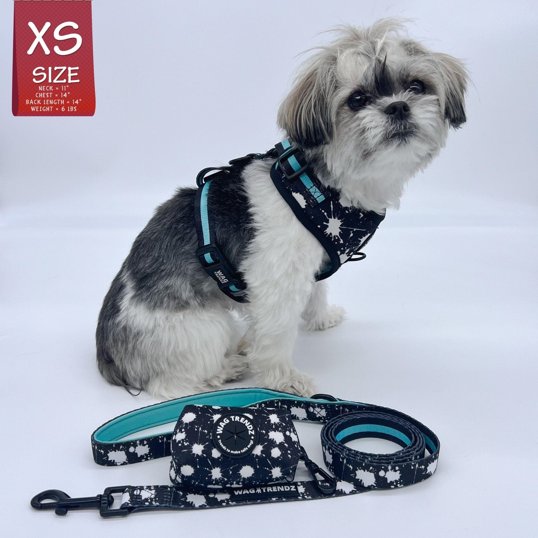 Dog Poop Bag Holder - Shih Tzu wearing black with white paint splatter harness vest with matching leash and poo bag holder - Wag Trendz rubber logo against solid white background -- Wag Trendz