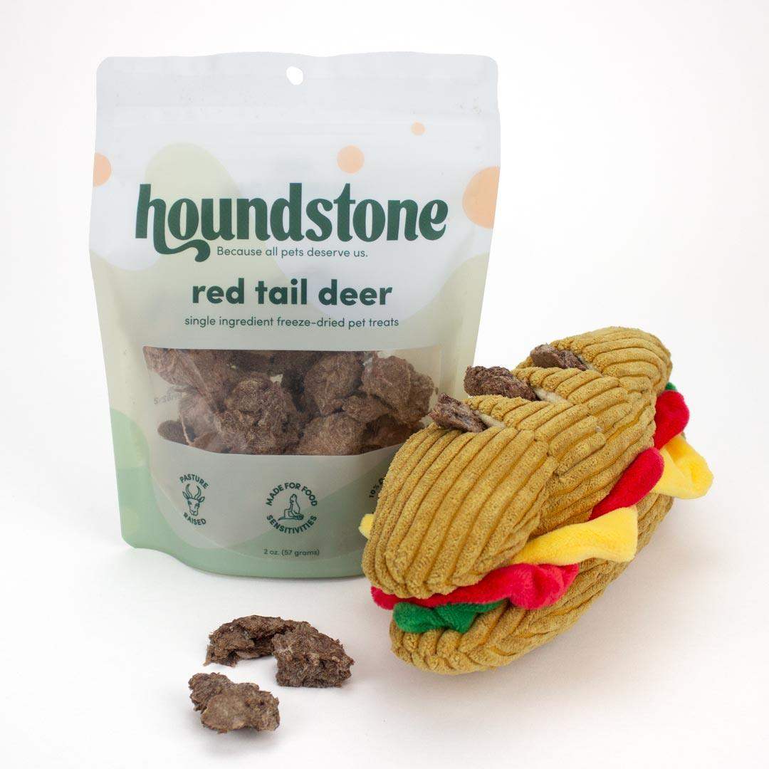 Houndstone red tail deer treats packaging with a dog squeaky toy shaped like a sandwich on a white background